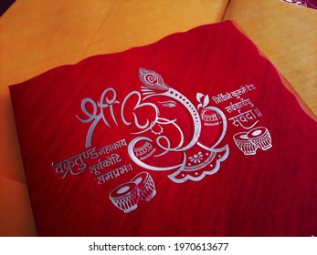 Rajasthan, India - 03.24.2021: Lord Ganesha Calligraphy On Red Colored Indian Wedding Invitation Card