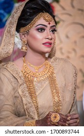 Rajshahi, Bangladesh- January 17, 2019. Beautiful Traditional Bangladeshi Girl In Bride Look Light Pinkish Clothes And Gold Jewellery With Makeup In Dark Background.