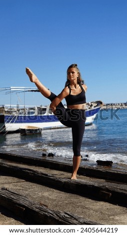Rajski ptak, pozycja jogi. Kobieta ćwicząca jogę nad morzem, statek w tle. Zdjęcia stock © 