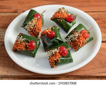 Rajwadi masala paan, Indian Traditional Mouth Freshener wrapped in betel leaf, often used as an after dinner digestive. served over a white plate on a rustic wooden background, selective focus