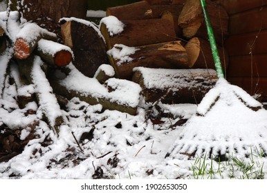 Rake And Garden Tools Covered In Snow In The British Winter. A Rake Covered In Snow.  January Gardening Weather In The UK.