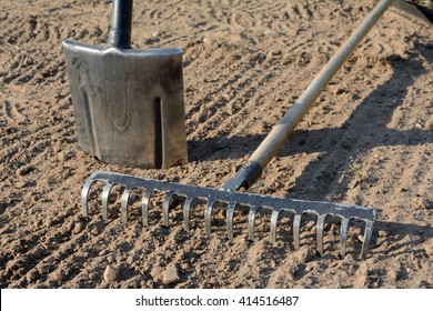 Rake And Spade On Loosened Soil Closeup