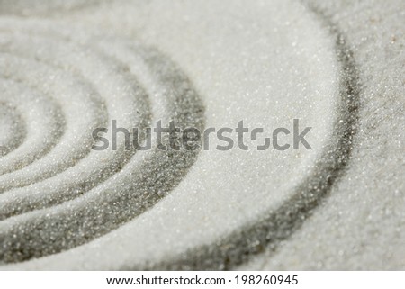 Raked sand background pattern and texture in a Japanese zen garden with concentric circles for meditation, tranquility and wellness.