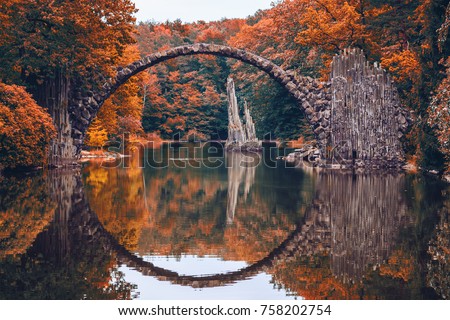 Rakotz Bridge (Rakotzbrucke, Devil's Bridge) in Kromlau, Saxony, Germany. Colorful autumn, reflection of the bridge in the water create a full circle
