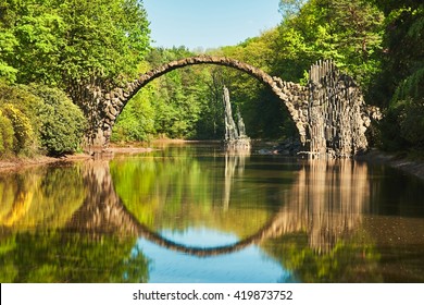 Rakotzbrucke also known as DevilÃ¢??s Bridge in Kromlau in Germany. Reflection of the bridge in the water create a full circle. - Powered by Shutterstock