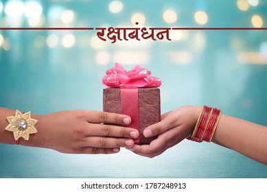 Raksha Bandhan (rakhi, Rakshabandhan) Concept, Indian Brother Giving Gift To His Sister, Raksha Bandhan Hindi Calligraphy And Marathi Calligraphy Which Reads As ' Raksha Bandhan