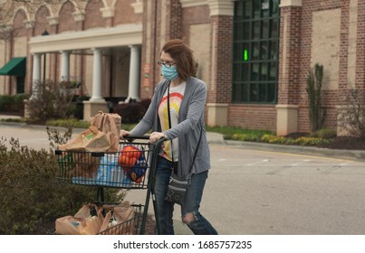 Raleigh, NC/United States- 03/27/2020: A Woman Exits A Grocery Store Wearing A Mask Amid The Coronavirus Epidemic. 