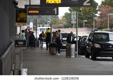 Raleigh, NC/United States- 11/12/2018: Airline Passengers Gather Baggage At The Curb Before Entering RDU International Airport. 