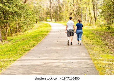 Raleigh, North Carolina USA-03 31 2021: A Couple Holding Hands Walks Along the Neuse River Trail on a Spring Morning.