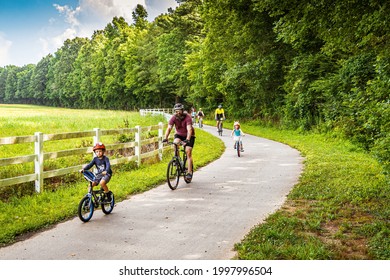 Raleigh, North Carolina USA-06 27 2021: Cyclists of All Ages Enjoy a Sunday Morning Ride on the Neuse River Trail.