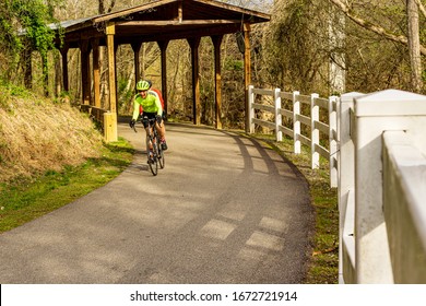 Raleigh,NC/USA-3/14/20: Cyclers Pass Under The Covered Bridge On The Neuse River Trail.