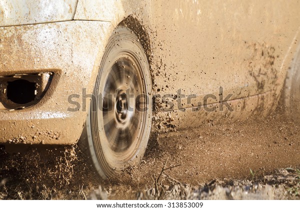 Rally car in muddy\
road