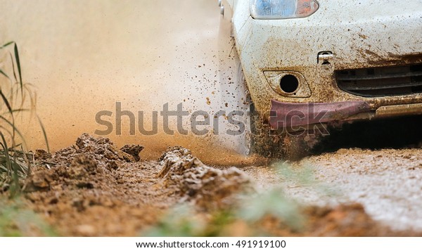 Rally car in muddy\
road