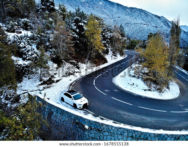 rally car and snow on\
roads of pyrenees 