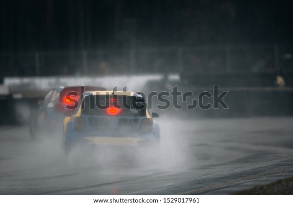 Rally cross cars ride\
fast during rain