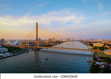 Rama 8 Bridge and Chao Phraya River in structure of suspension architecture concept, Urban city, Bangkok. Downtown area at sunset, Thailand.