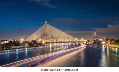 Rama 8 Bridge over the Chao Phraya River with light trails in Twilight. It is one of famous Bangkok's landmarks in Thailand and easily recognized by its beauty and unique architecture.