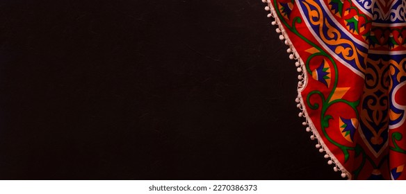 Ramadan Background with copy space - Top View of a black wooden table with Ramadan Islamic , Arabian traditional fabrics - Shutterstock ID 2270386373