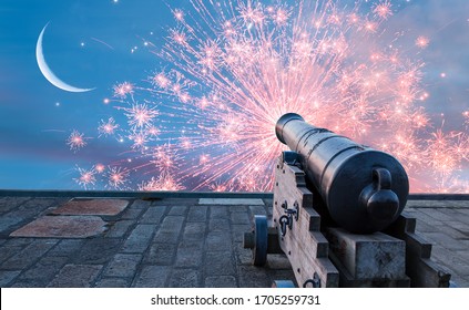 Ramadan Concept - Ramadan kareem cannon with crescent and fireworks - Night sky with moon in the clouds at sunset