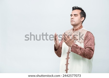 Ramadan, EIDMUBARAK, Asian Muslim men are praying with faithful faces and following Islamic practices, on white background, with copy space.
