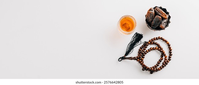 Ramadan flat lay, dates fruit, rosary beads, and tea on a clean white background. Celebrating the Muslim festival with traditional Arab elements. Ramadan celebration