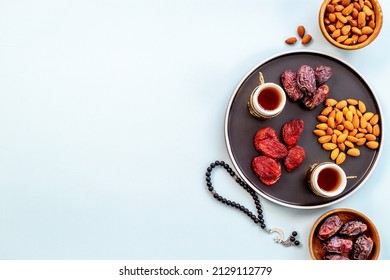 Ramadan holyday table with dates fruits and islamic rosary with star and crescent - Shutterstock ID 2129112779