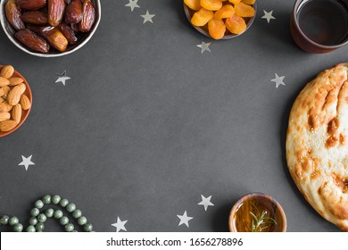 Ramadan  Iftar Food - Date Fruits, Ramadan Fresh Bread, Olive Oil, Water, Almonds, Apricots On Black, Top View, Copy Space. Ramadan Kareem Concept.