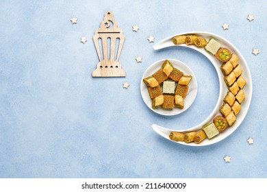 Ramadan kareem with baklava sweets  arranged in shape of crescent moon. Iftar food concept. Top view, copy space - Shutterstock ID 2116400009