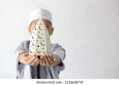 Ramadan kareem concept. Muslim boy holding ramadan decoration isolated on white background - Shutterstock ID 2124638759