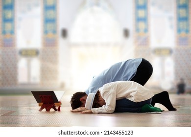 Ramadan Kareem greeting. Father and son in mosque. Muslim family praying. Man and child read Quran and pray. End of fasting. Hari Raya day. Eid al-Fitr celebration. Breaking of holy fast day. 