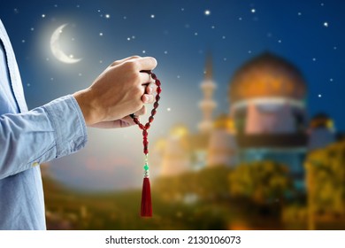 Ramadan Kareem greeting. Man with prayer beads in mosque. Muslim male praying. Quran reading and pray. End of fasting. Hari Raya day. Eid al-Fitr celebration. Breaking of holy fast day. 