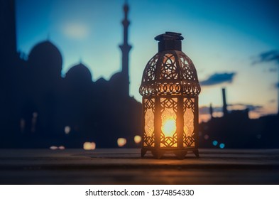 Ramadan Kareem greeting photo with serene mosque background with beautiful glowing lantern. 