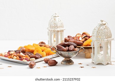 Ramadan Kareem and iftar muslim food, holiday concept. Trays with nuts and dried fruits and latterns with candles. Celebration idea - Shutterstock ID 2115237932