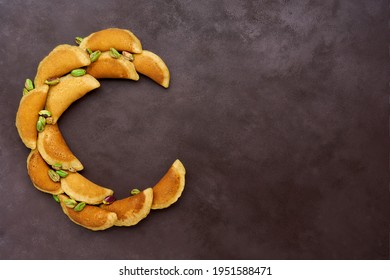 Ramadan Kareem With Qatayef Arranged In Shape Of Crescent Moon. Traditional Middle Estern Ramadan Sweets. Iftar Food Concept. Top View, Copy Space                           