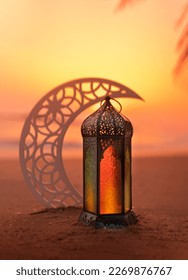 Ramadan Lantern on the beach with crescent moon shape during sunset, 2023 Islamic concept image, Eid Mubarak Greeting background - Shutterstock ID 2269876767