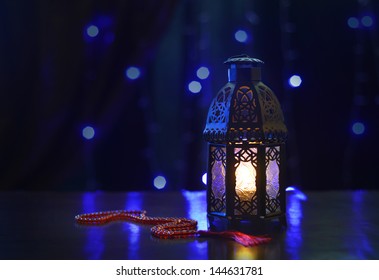 Ramadan lantern and rosary on dark background