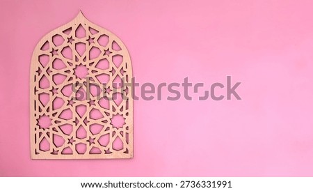 Ramadan pattern background, Intricately designed wooden panel featuring geometric and star patterns, mounted on a pink background. The panel is shaped like an arched window, commonly associated with Islamic architecture, evoking elements of traditional Middle Eastern design. The combination of light wood and soft pink adds a harmonious and serene ambiance, suitable for a Ramadan-themed decor.