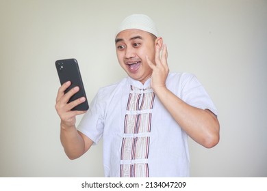 Ramadan Theme Side Profile Surprised And Excited Funny Asian Indonesian Malaysian Muslim Man Screaming Holding Mobile Phone