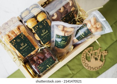 Ramadhan gift. Hampers moslem theme for celebrete the holy, bake snack, nastar, bakery, cookies, pudiing, chococips, roll cake, castangel.with greeting card and green accessories on white background - Shutterstock ID 2141470521