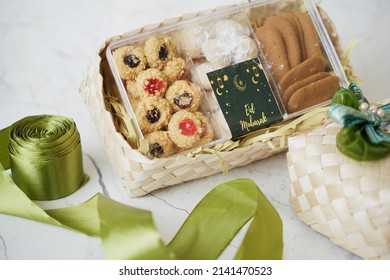 Ramadhan gift. Hampers moslem theme for celebrete the holy, bake snack, nastar, bakery, cookies, pudiing, chococips, roll cake, castangel.with greeting card and green accessories on white background - Shutterstock ID 2141470523