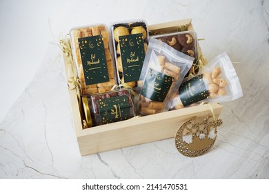 Ramadhan gift. Hampers moslem theme for celebrete the holy, bake snack, nastar, bakery, cookies, pudiing, chococips, roll cake, castangel.with greeting card and green accessories on white background - Shutterstock ID 2141470531