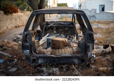 Ramallah, Ramallah And Al-Bireh Governorate, Palestine, 20 July 2022: Old Destroyed Vehicle By A Road Full Of Junk On An Empty Plot Of Land