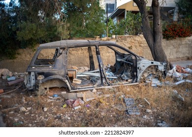 Ramallah, Ramallah And Al-Bireh Governorate, Palestine, 20 July 2022: Old Destroyed Vehicle By A Road Full Of Junk On An Empty Plot Of Land