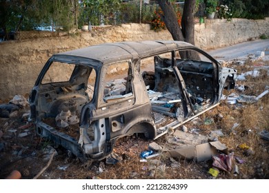 Ramallah, Ramallah And Al-Bireh Governorate, Palestine, 20 July 2022: Old Destroyed Vehicle By A Road Full Of Junk On An Empty Plot Of Land