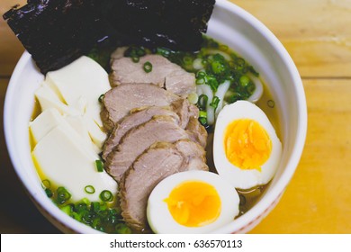 Raman Noodle With Pork And Eggs On Wooden Table.