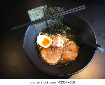 Raman Noodle In Restaurant .with Pork Boil Egg  In A Big Black Bowl