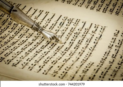 RAMAT GAN, ISRAEL. September 22, 2017. Torah "yad" pointer and the ancient Hebrew text of the Book of Genesis in the Torah scroll. Torah chapter read every Sabbath in a synagogue. Conversion Judaism
