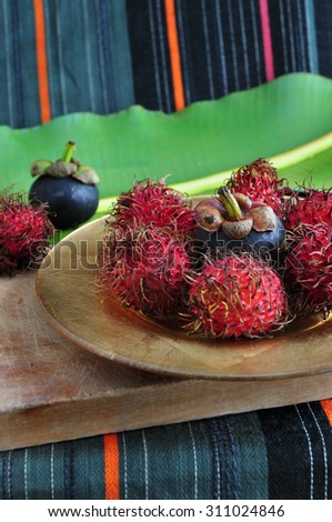 rambutan and mangosteen asian fruits on golden plate