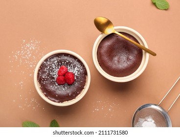 Ramekins with tasty lava cake fondant and raspberry on color background - Shutterstock ID 2111731580