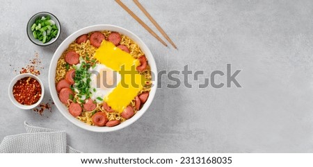 Ramen Noodles with Sausages, Egg, Melted Cheese and Scallion, Microwave Shin Ramyeon or Ramyun,Korean Noodles on Bright Background